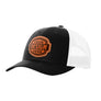 A black trucker-style cap with a white mesh back and a brown 'your design here' leather patch on the front panel, shown on a plain white background.