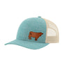 A heathered blue trucker-style cap with a tan mesh back and a brown cow leather patch on the front panel, shown on a plain white background.