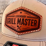 a tan hat with a brown, hexagon leather patch that reads "grill master"
