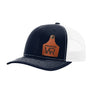 A navy blue trucker style hat with a white mesh back, and a leather cattle tag shaped patch engraved with "wr" on a white background