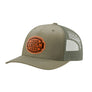 An olive green trucker-style cap with a green mesh back and a brown 'your design here' leather patch on the front panel, shown on a plain white background.