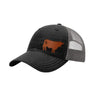 A black trucker-style cap with a grey mesh back and a brown cow leather patch on the front panel, shown on a plain white background.