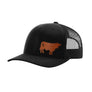 A black trucker hat with a curved brim, black mesh back, and a brown cow leather patch on the front, shown against a plain white background.