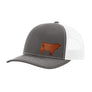 A dark gray trucker hat with a white mesh back, and a brown cow leather patch on the front panel, shown against a plain white background.