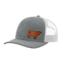 A gray textured trucker hat with light gray mesh back, and a brown leather cow patch on the front, shown against a plain white background.
