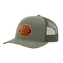 An olive green trucker-style cap with a green mesh back and a brown 'your design here' leather patch on the front panel, shown on a plain white background.