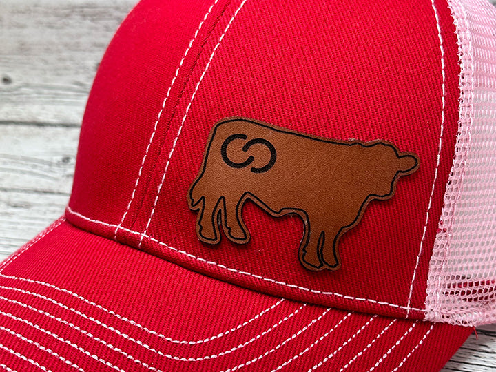 red baseball hat with leather cow shape patch